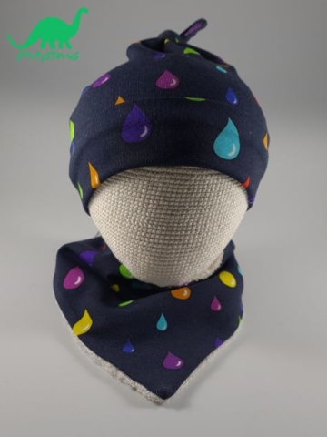 Rainbow drops organic cotton fabric knot-tie hat and bib on crocheted baby head