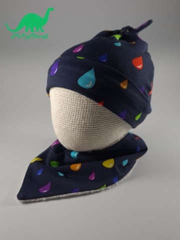 Rainbow drops organic cotton fabric knot-tie hat and bib on crocheted baby head