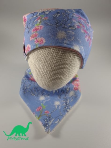 Floral slouch beanie hat and bib on crocheted baby head
