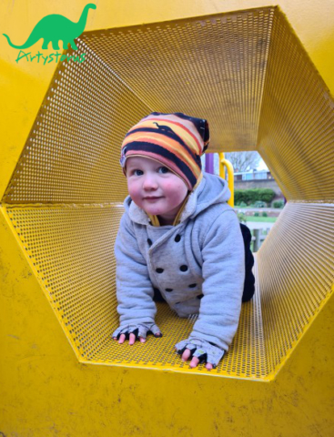 Child outside wearing sunset dinosaur slouch beanie hat