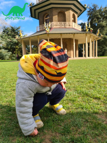 Child outdoors wearing sunset dinosaur slouch beanie hat