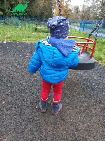 Child outside beside swing wearing organic cotton red leggings and Space Maths slouch beanie